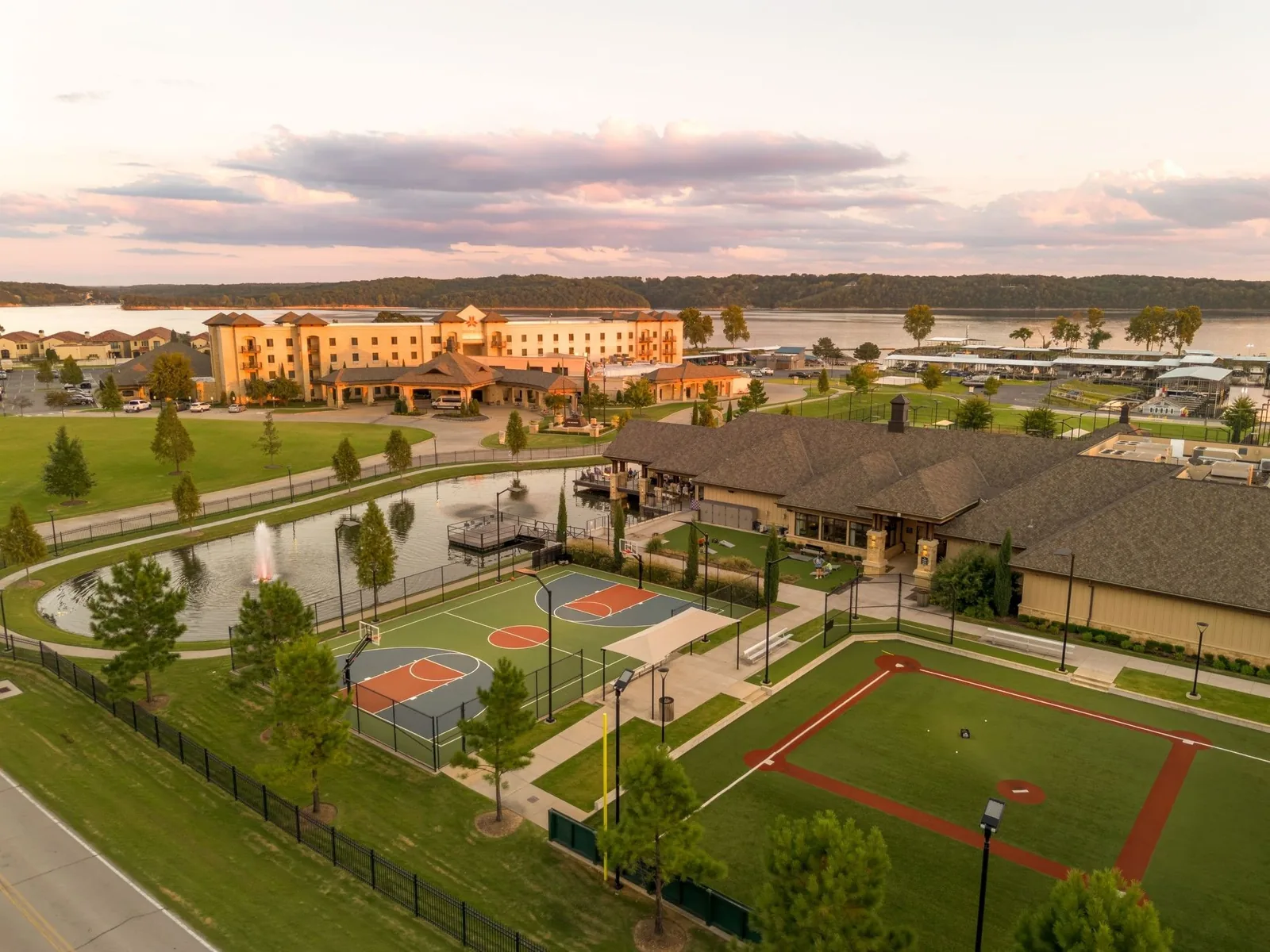 Aerial view of the outdoor basketball court and mini baseball field beside a pond at Shangri-La Resort